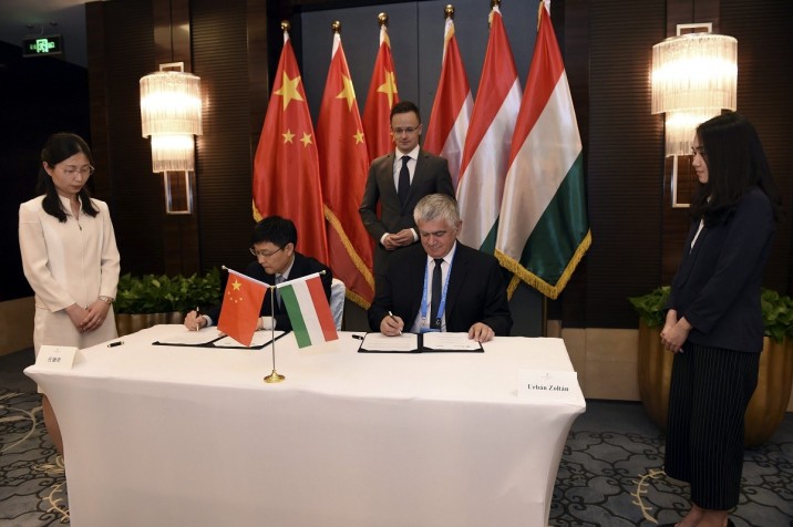 A Külgazdasági és Külügyminisztérium által közzétett képen Csang Ji, a Bank of China alelnöke  (b) és Urbán Zoltán, az Eximbank vezérigazgatója együttműködési megállapodást ír alá Pekingben 2017. május 12-én. Mögöttük Szijjártó külgazdasági és külügyminiszter. MTI Fotó: Kkm